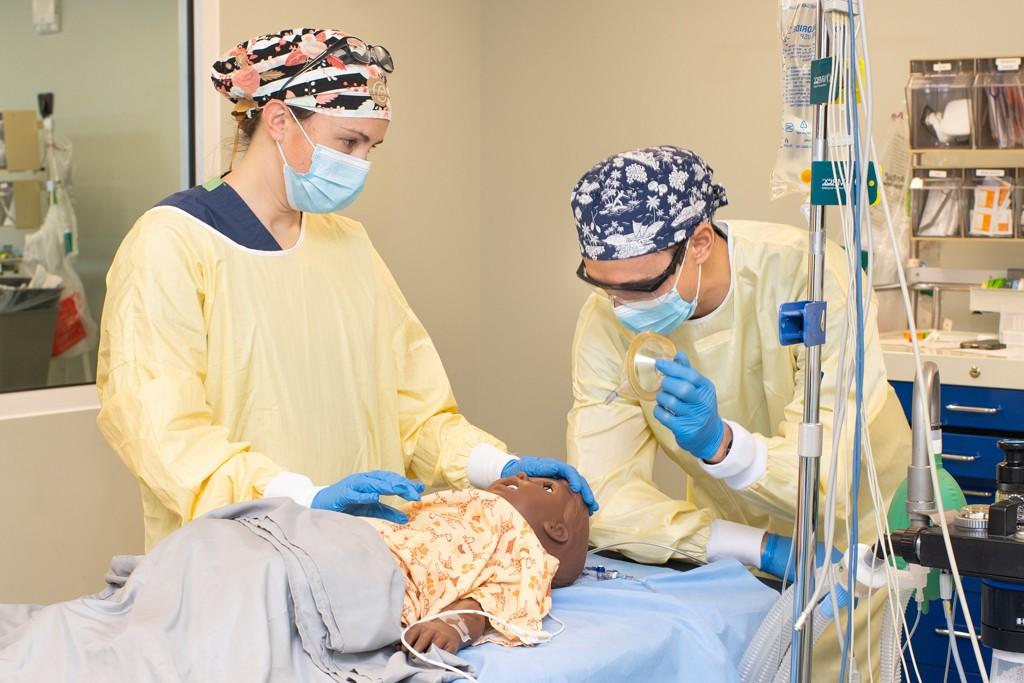 Two U N E D N P students practice on a patient simulator